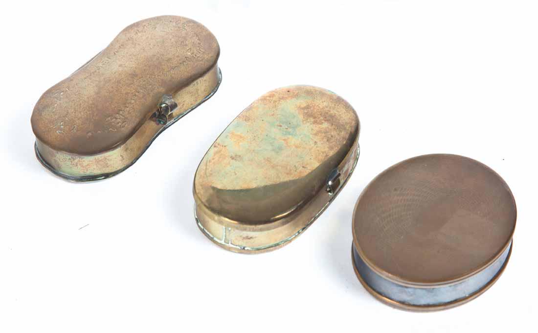 THREE BRASS SNUFF BOXES: Two oval, one with etched decoration on lid. 2.75"w. 3"w. One bowtie-shaped with engraved floral decoration on lid. 3.75"w.