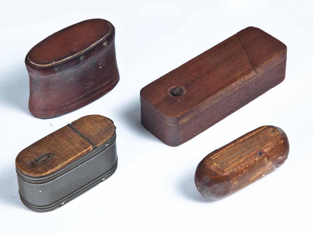 FOUR WOOD SNUFF BOXES: One puzzle box with swivel lid. 4.25"w. One cylindrical with slide lid. 2.75"w. One with tin sides and wood hinged lid and bottom. 2.75"w. One stitched leather over wood. 2.75"w.