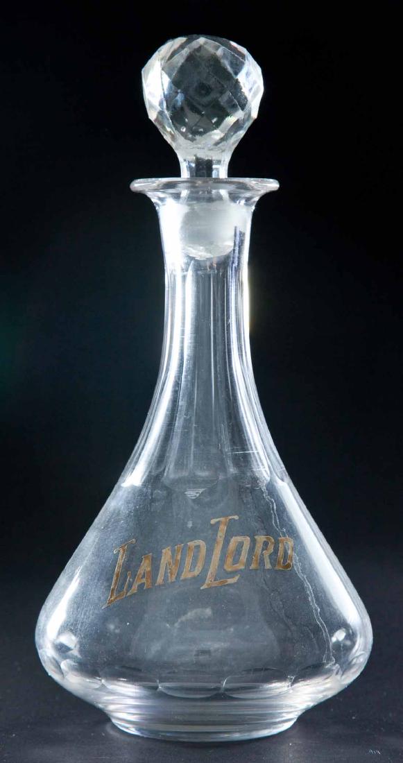 ENAMELED LABEL BAR BOTTLE: Colorless pre-Prohibition bottle with "Land Lord" advertising. With faceted ball stopper. 10"h.