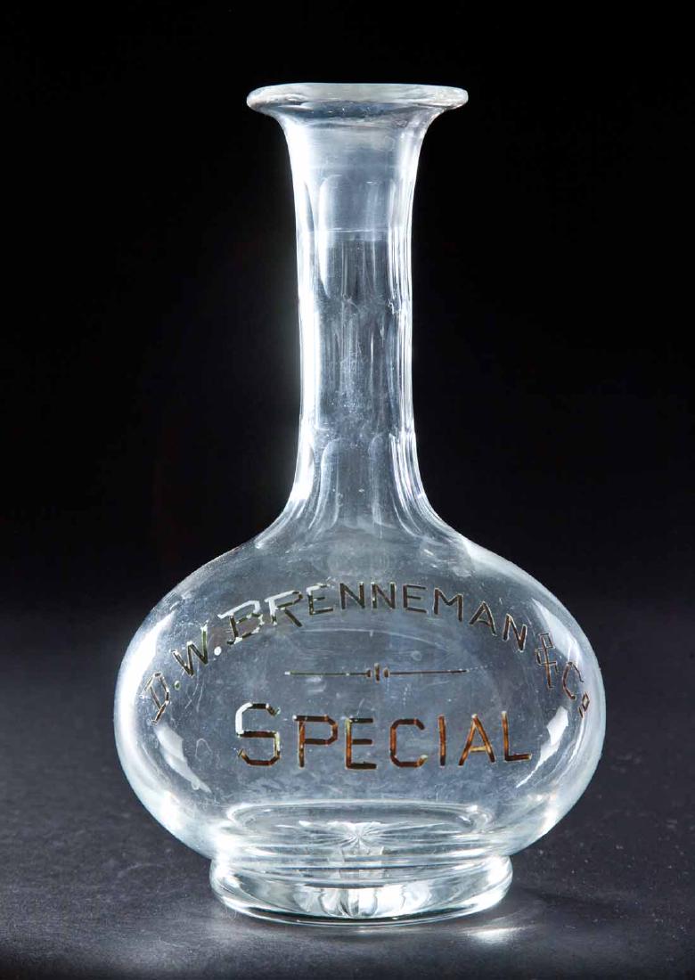 ENAMELED LABEL BAR BOTTLE: Colorless pre-Prohibition bottle with bulbous base, paneled neck with oval cutting and label for "D.W. Brenneman & Co. Special". 8.5"h.