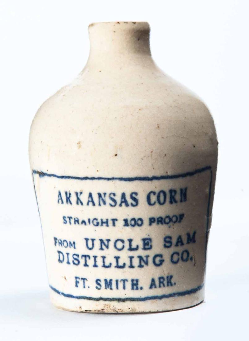 FORT SMITH, ARKANSAS MINIATURE ADVERTISING JUG: Cream glaze and stamped advertising "ARKANSAS CORN STRAIGHT 100 PROOF FROM UNCLE SAME DISTILLING COâ€¦" 3.25" high.