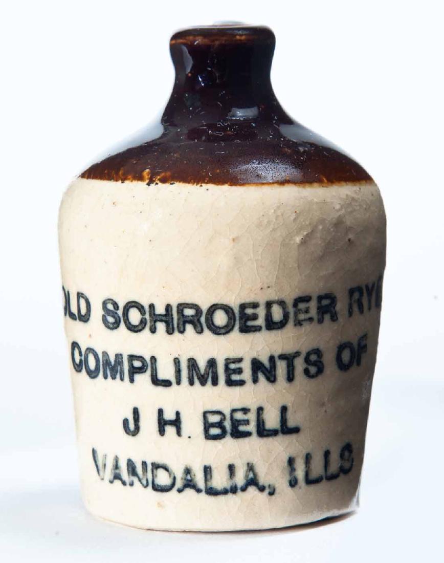 VANDALIA, ILLINOIS MINIATURE ADVERTISING JUG: Bicolor glaze and stamped decoration "OLD SCHROEDER RYE COMPLIMENTS OF J.H. BELLâ€¦" 3" high.