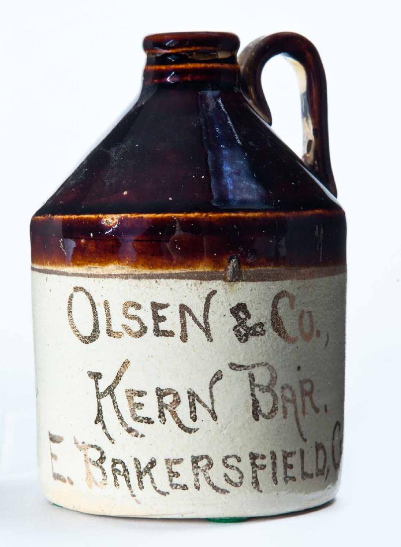 BAKERSFIELD, CALIFORNIA MINIATURE ADVERTISING JUG: Bicolor glaze and gilt advertisement "OLSEN & Co. KERN BARâ€¦" 4.5" high.