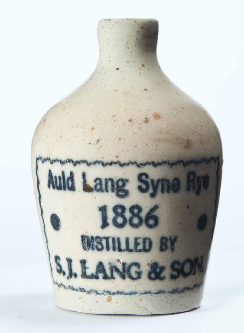 MINIATURE ADVERTISING JUG: Cream glaze and stamped advertisement "Auld Lang Syne Rye 1886 DISTILLED BY S.J. LANG & SON." 3" high.