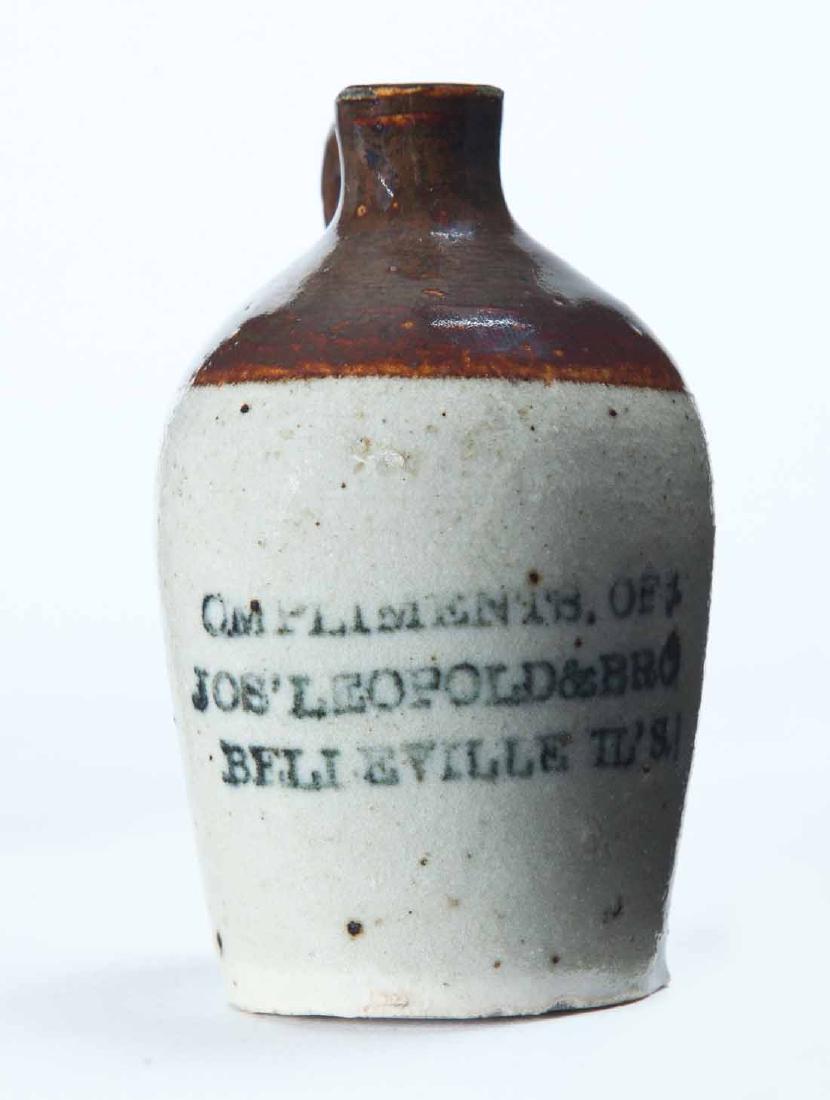 BELLEVILLE, ILLINOIS MINIATURE ADVERTISING JUG: Bicolor glaze and stamped advertisement "COMPLIMENTS OF JOS' LEOPOLD & BROâ€¦" 3.25" high.