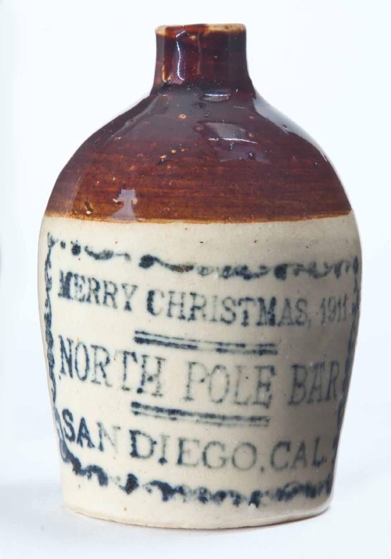 SAN DIEGO, CALIFORNIA MINIATURE ADVERTISING JUG: Bicolor glaze and stamped advertisement "MERRY CHRISTMAS 1911 NORTH POLE BARâ€¦" 3.75" high.