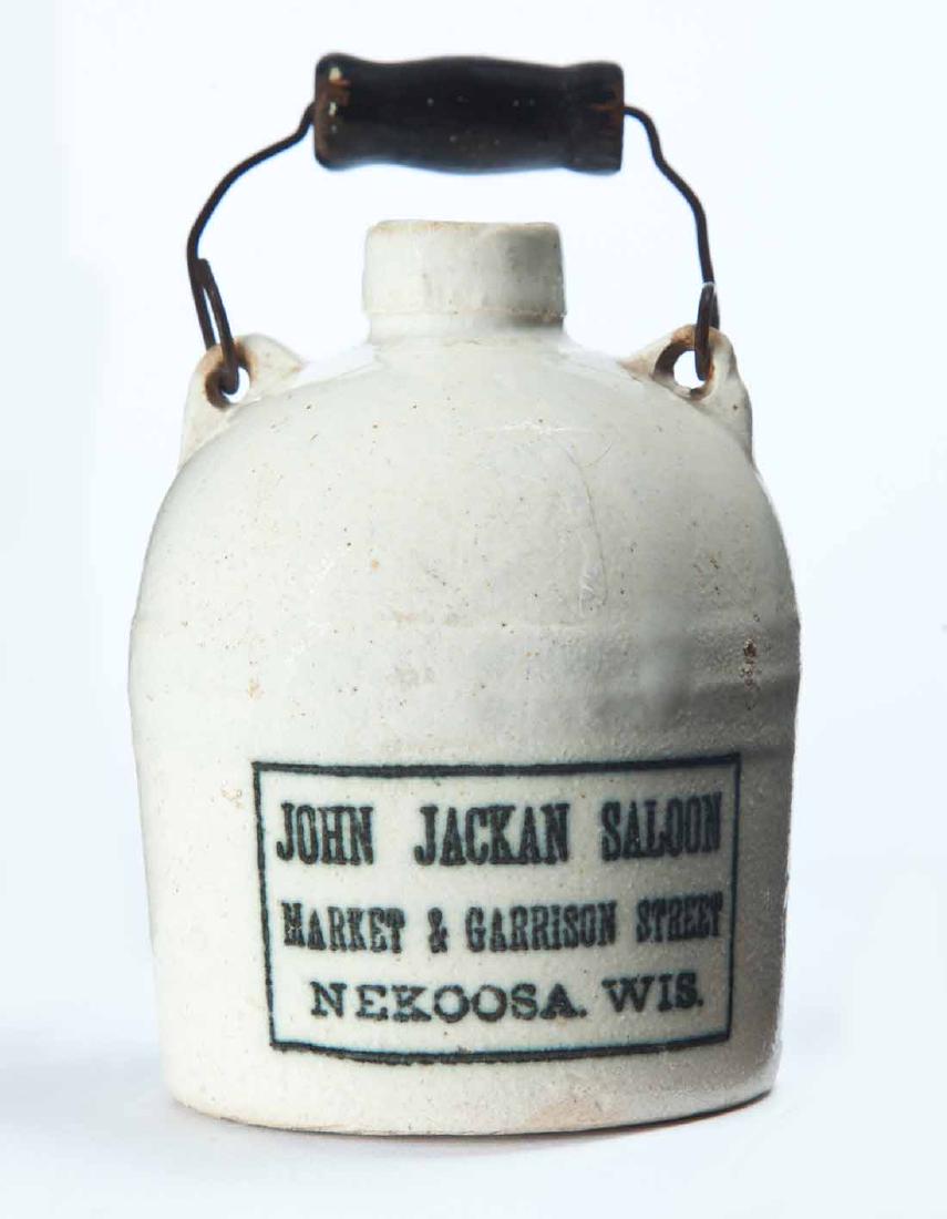 NEKOOSA, WISCONSIN MINIATURE ADVERTISING JUG: White glaze, bail handle, and stamped advertisement "JOHN JACKAN SALOONâ€¦" 3.25" high, excluding handle.