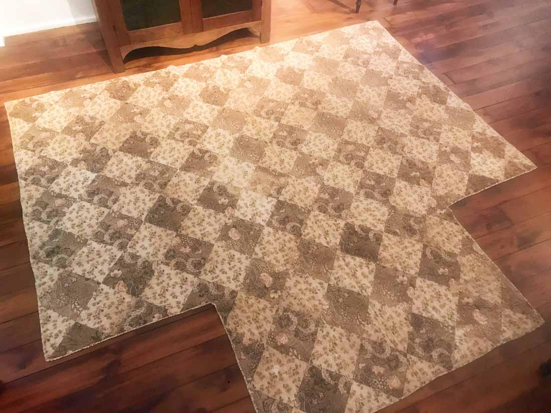 EARLY CHINTZ QUILT: American, early 19th century, fitted to accommodate a four poster bed. The quilt is made from 7.5" squares of fabric and quilted at 5 - 6 stitches per inch. 102.5" by 93.5". This lot is eligible for p