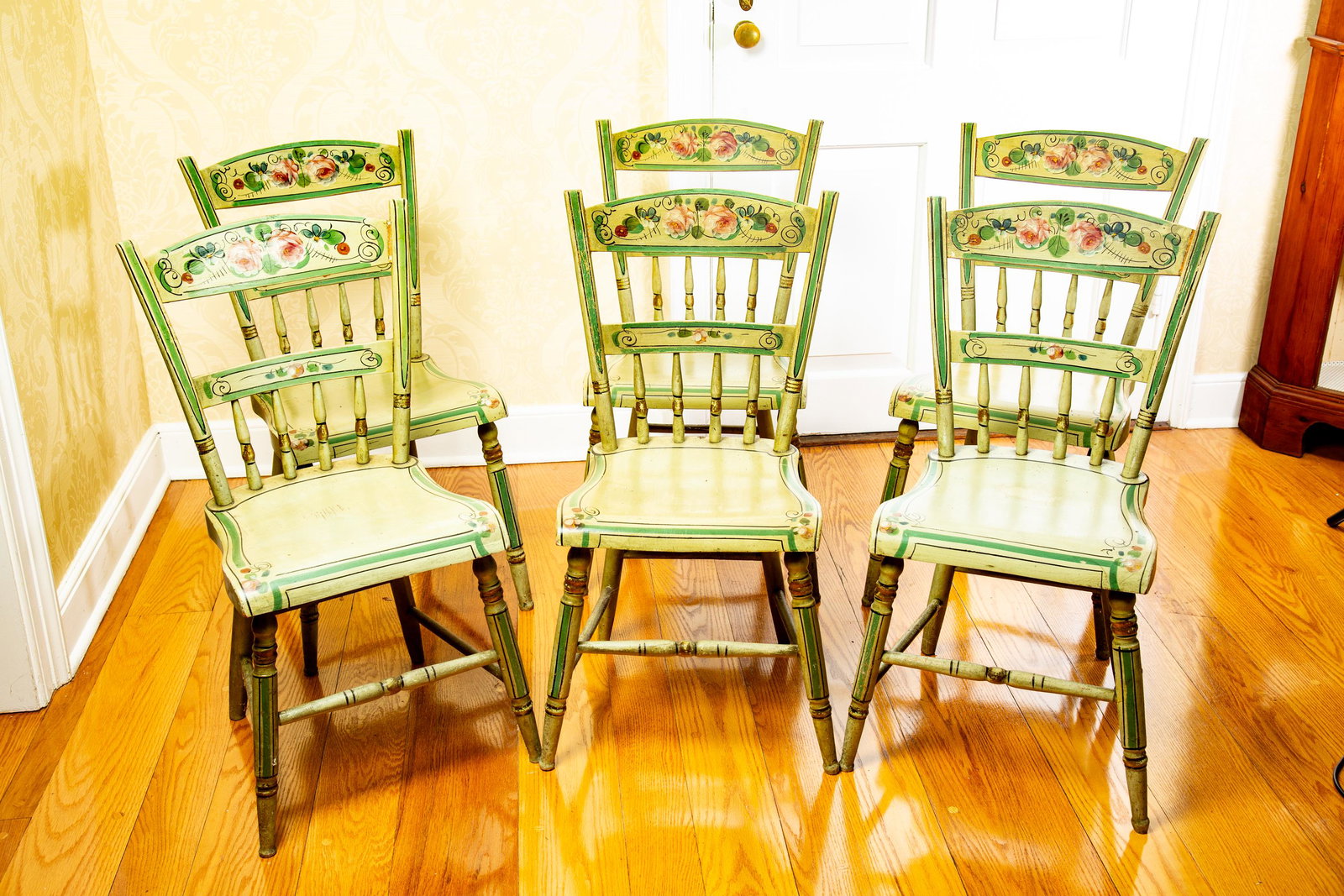 SET OF 6 DECORATED CHAIRS: Probably Pennsylvania, c. 1830, mixed woods. Half-spindle windsors with their original floral decoration on a light green ground. 31.5" high. (P1)