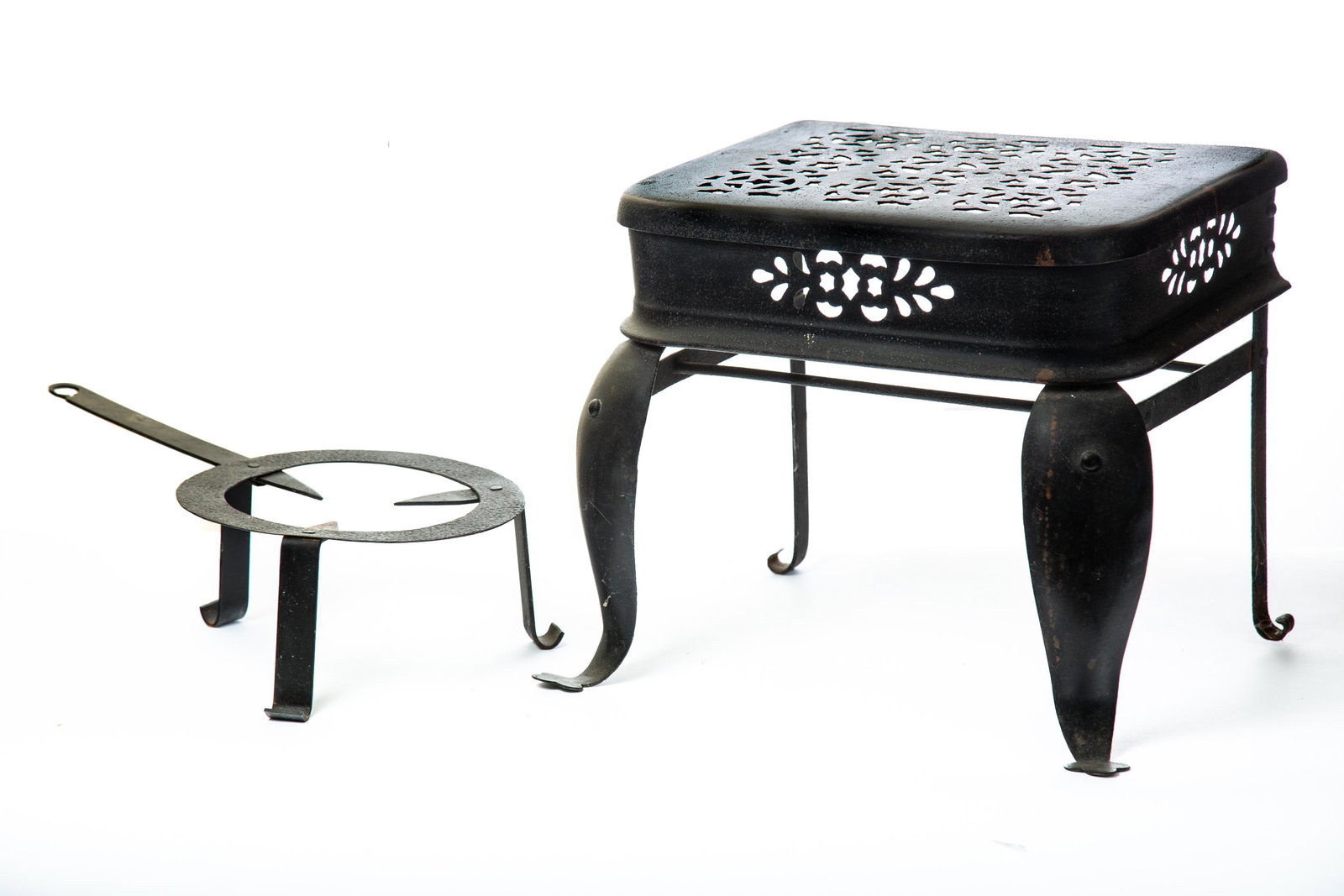 FOOTMAN AND TRIVET: 19th-20th century, iron. Includes a period sheet-iron footman with a star design, 13" high, and a vintage reproduction trivet, 17" long. (LR46)
