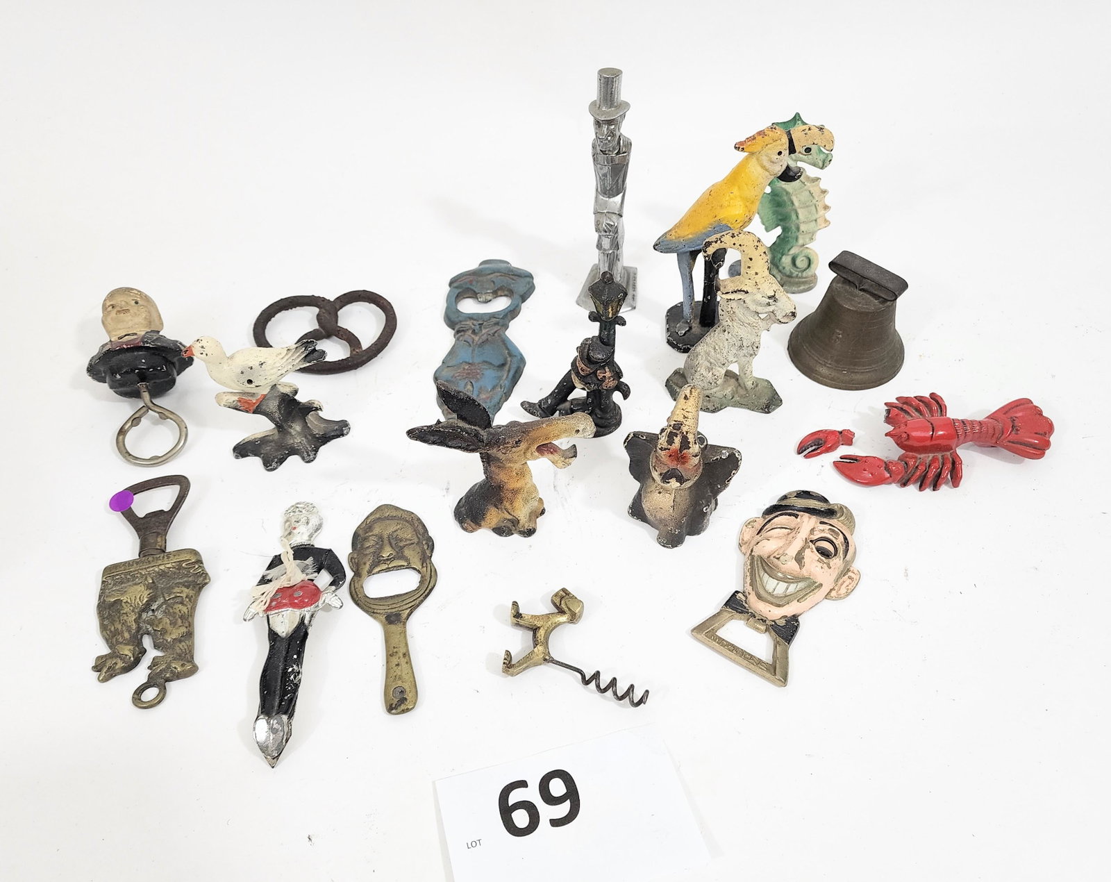 COLLECTION OF CAST IRON, INCLUDING BARWARE: Early 20th century painted iron figures including a bell, two men, pretzel, duck, donkey, goat and sealion, brass corkscrew (1) and bottle openers (7).