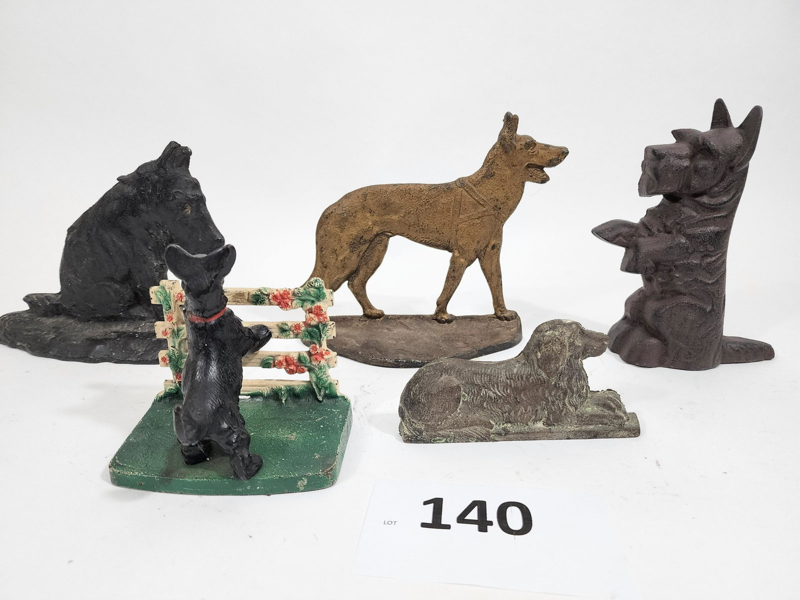 FIVE DOG DOORSTOPS: Late 19th-early 20th century, cast iron. 2.75" high to 7.25" high.