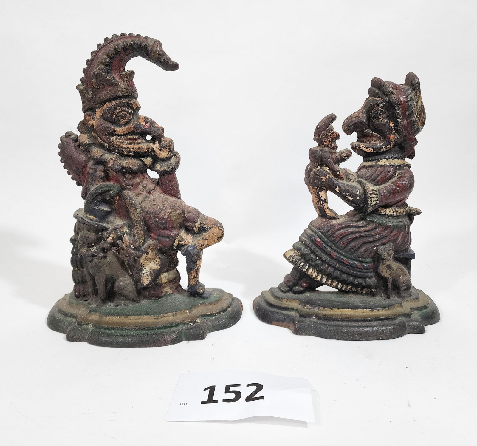 PUNCH AND JUDY DOORSTOPS: Late 19th century, cast iron. Retain some of their original paint. 12" and 10.5" high.
