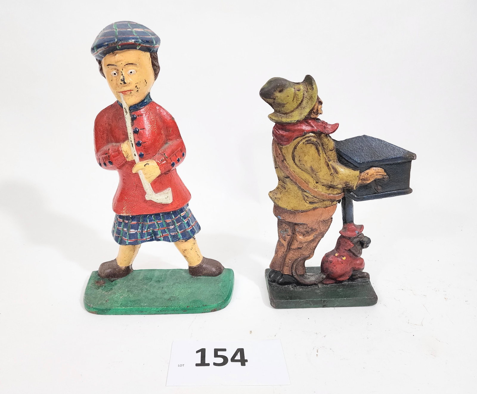 TWO DOORSTOPS: SCOTSMAN AND ORGAN GRINDER: Late 19th-early 20th century, cast iron. Includes a Scotsman in a kilt and an organ grinder and his monkey, 12" and 10" high.