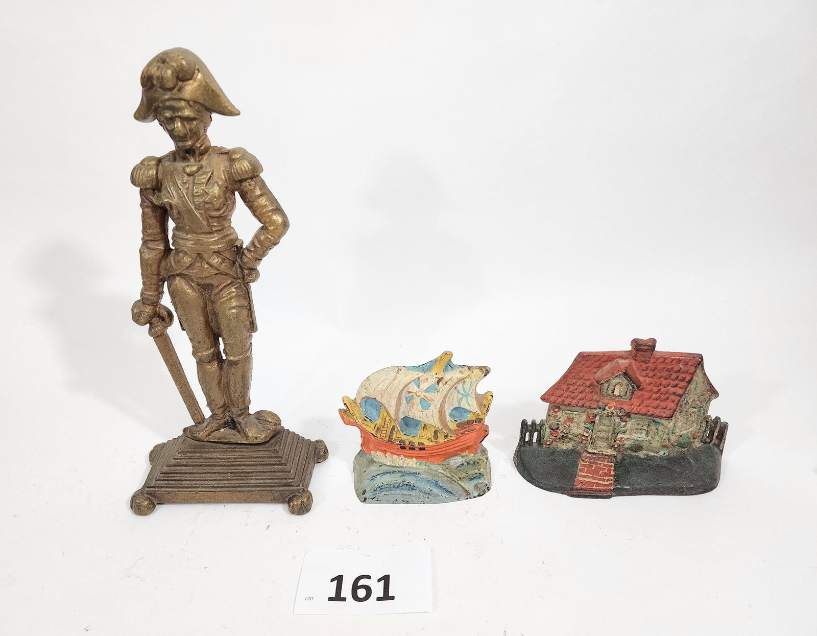 THREE DOORSTOPS: Late 19th-early 20th century. Includes Admiral Lord Nelson, a ship, and a house, 5" to 14.25" high.