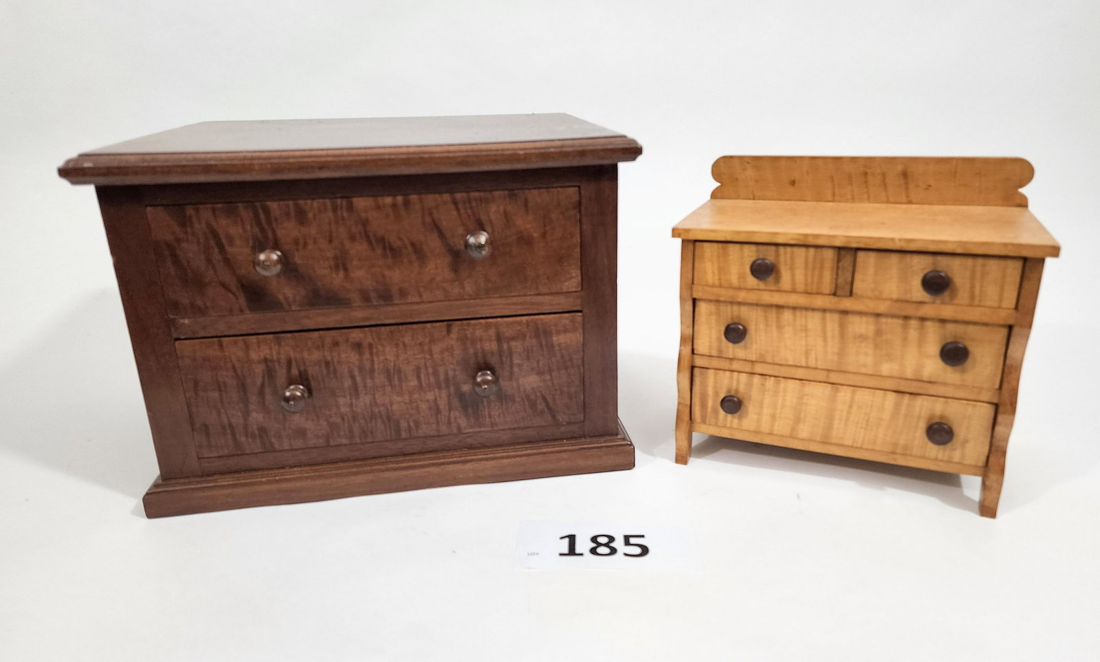 TWO MINIATURE CHESTS OF DRAWERS: 20th century. Incldues a doll-sized curly maple 4-drawer chest, 7.5" high, and a two drawer figured mahogany chest, 12" wide.