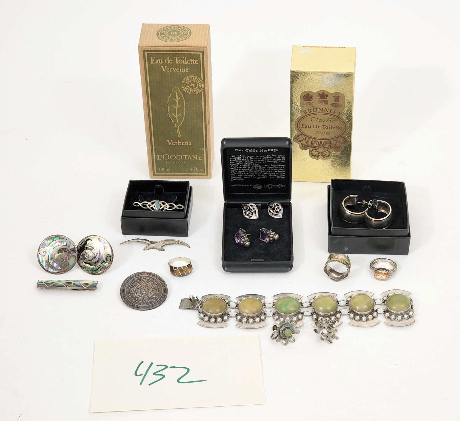 COLLECTION OF SILVER JEWELRY, PLUS COLOGNE: American, Mexican and Scottish 20th century silver, including a Mexican demi-parure bracelet and earring set, a Mexican tiger eye and Aztec calender pin, a gentlemen's pair of abalone cufflinks and ti