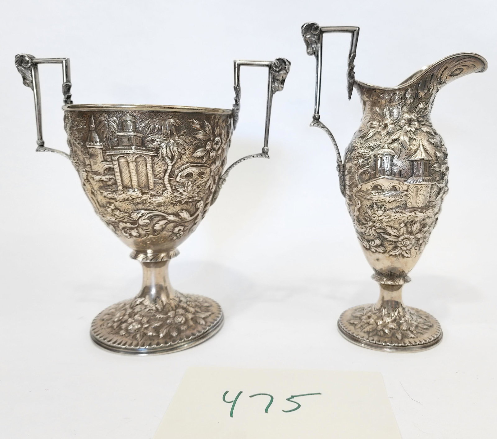 SILVER CUP AND EWER OF SOUTHERN HISTORICAL INTEREST.: Both marked for Samuel Lewis , Washington DC (the ewer with a stamped mark and the trophy with an engraved mark). Elaborate scenic repousse decoration, with ram's heads handles. 9.25" and 8.5" high, a