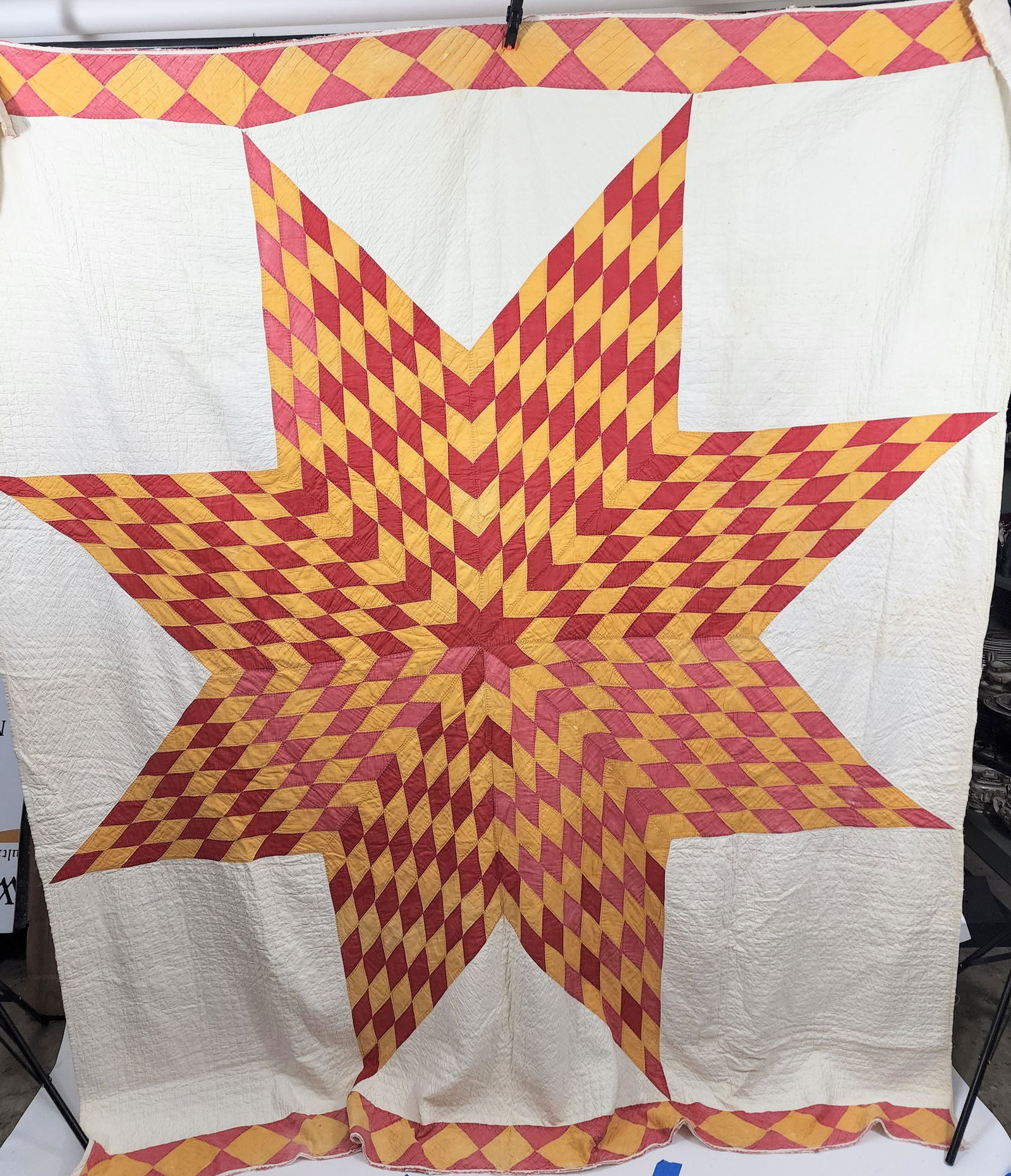 AMERICAN LONE STAR QUILT: Early 20th century. Lone star quilt in red and gold on white ground; gold-diamonds on red border with 2 different red fabrics, one red has faded, probably not kit quilt. Approx. 90" x 78".