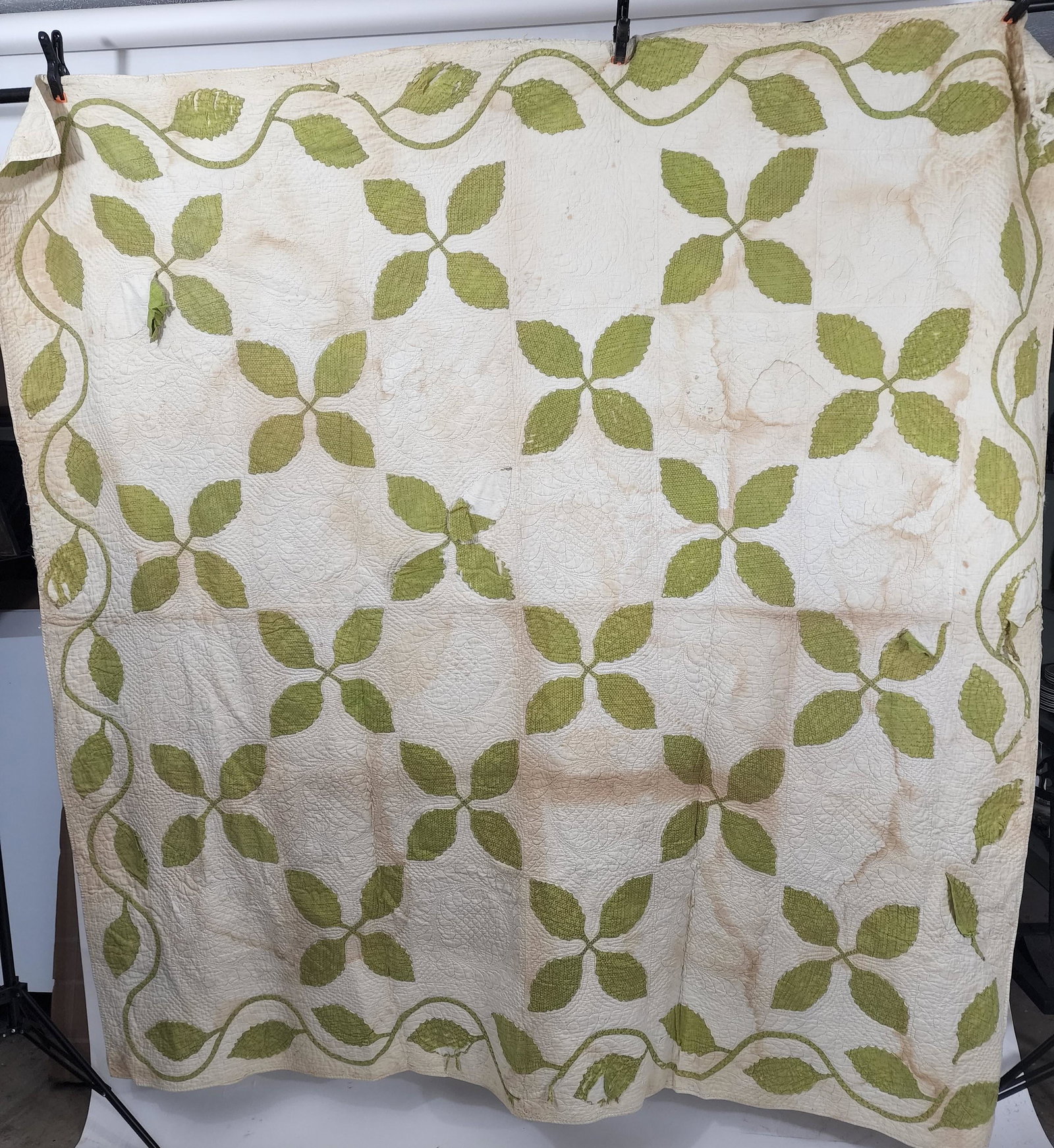 AMERICAN PIECED QUILT: Mid-19th century. Green leaf appliquÃ© quilt with double feathered wreaths and echo quilting around the leaves; vine & leaf border, all hand made. Approx. 78" square.
