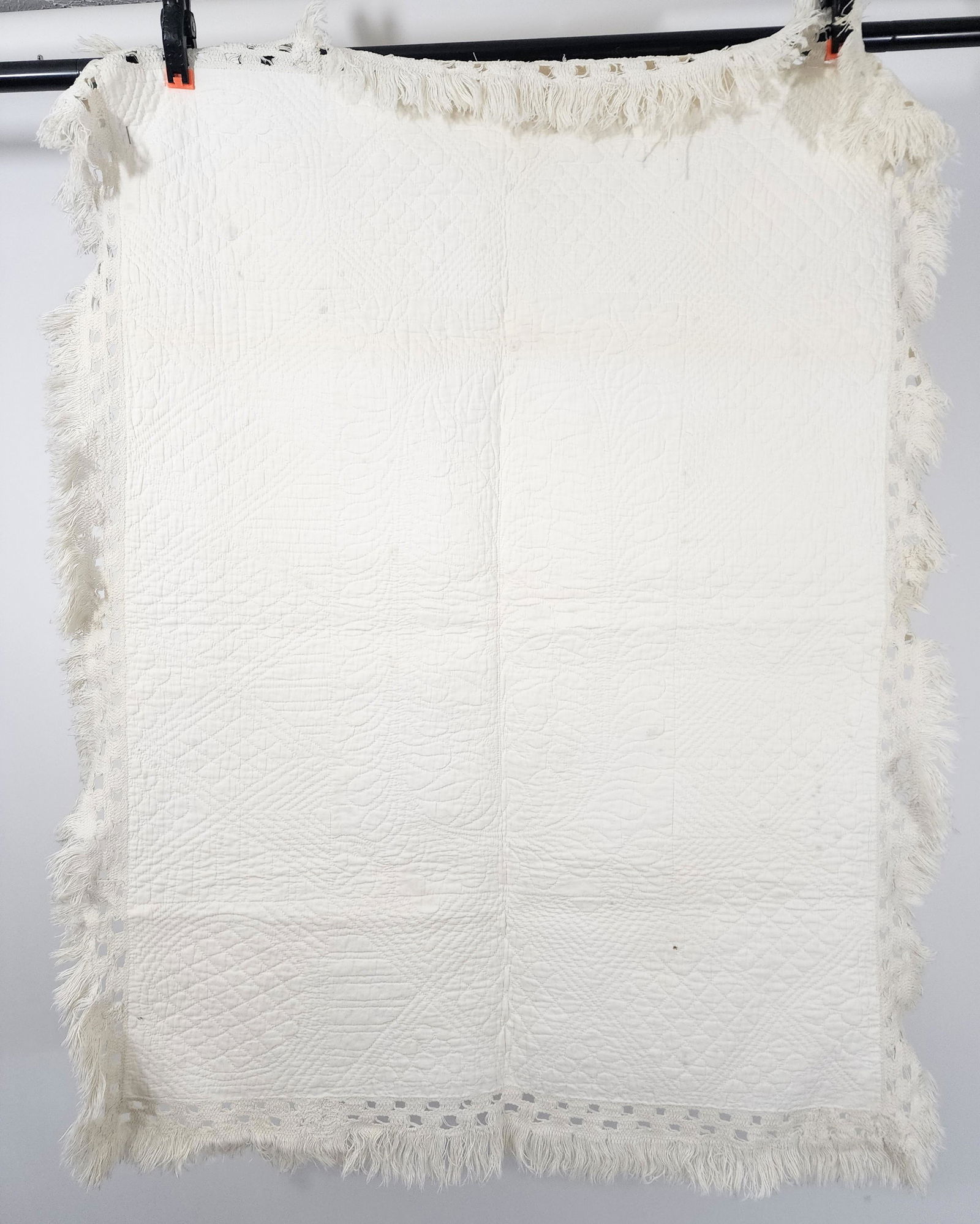 AMERICAN WHITEWORK CRIB QUILT: Attributed to Springfield, Illinois, 2nd quarter-19th century. White on white wholecloth crib quilt. Fringe edge. Quilted central medallion with cross hatched squares on point quilted in border area w