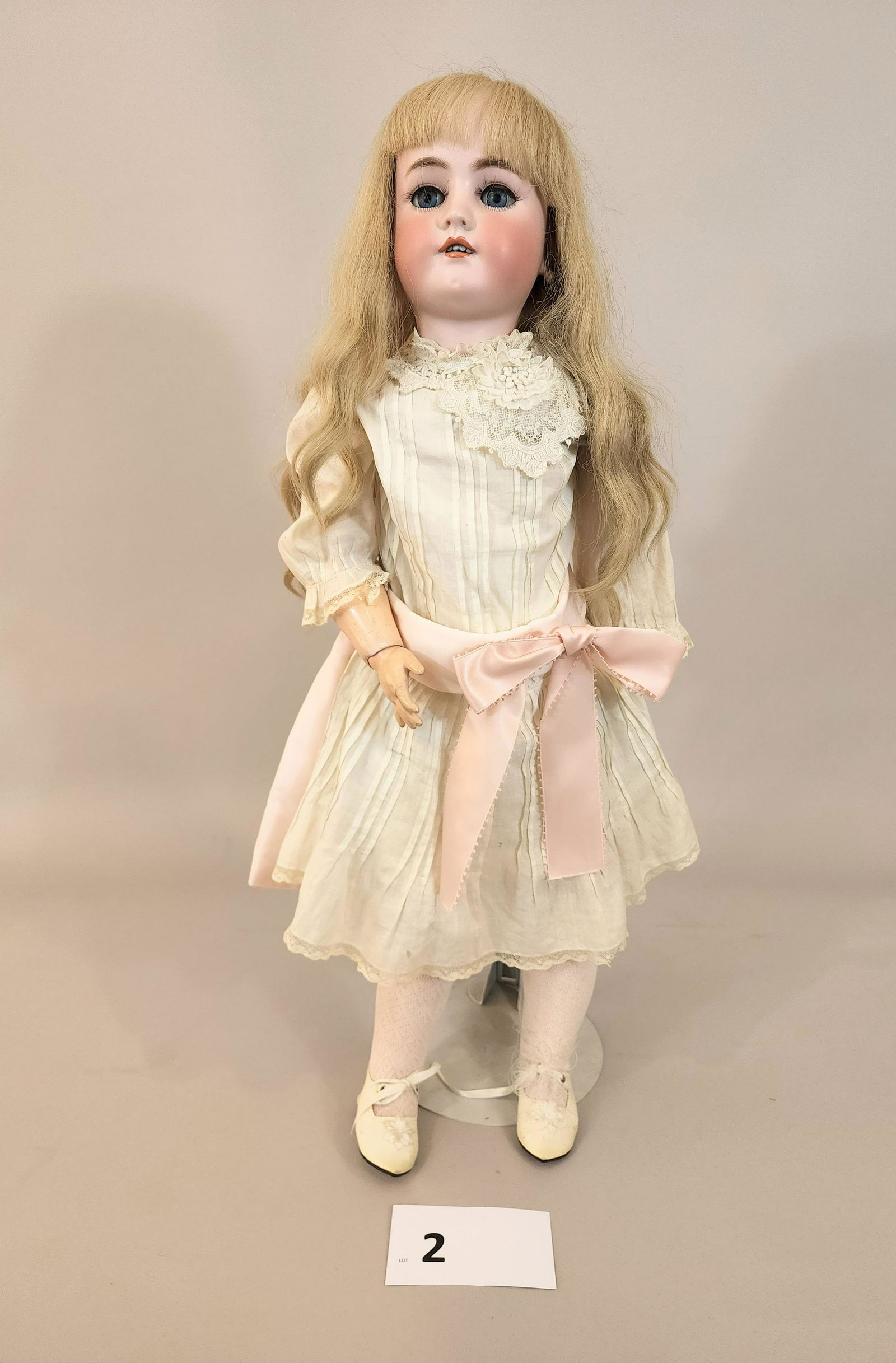 SIMON & HALBIG HEINRICH HANDWERCK 29" DOLL: Bisque head, composition body, with blonde hair, white dress with lace and pink sash, blue sleepy eyes.