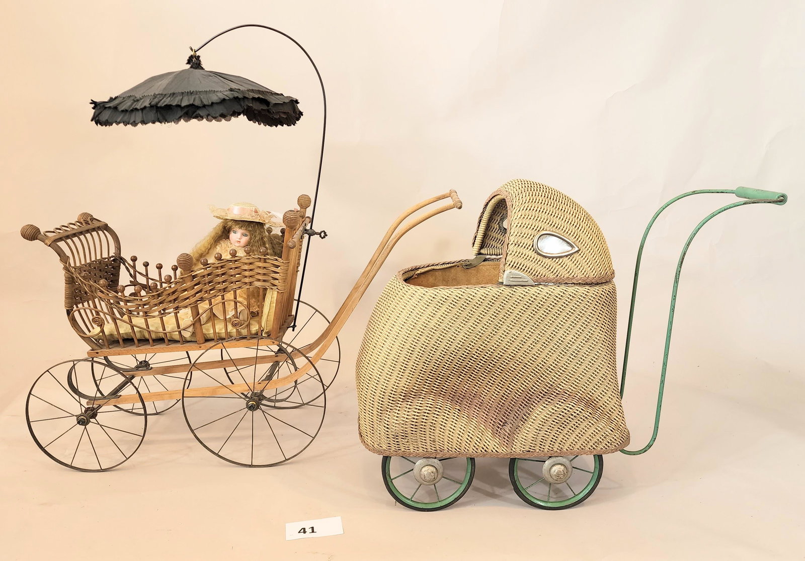 TWO DOLL CARRIAGES AND TRICYCLE: Wicker and rattan doll carriages, one Victorian with black parasol, one in car form with shaped wicker fenders and green painted frame, and old iron tricycle. Includes contemporary doll. Victorian car