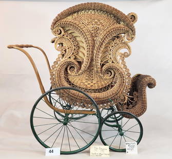 "THE EMPEROR" BABY CARRIAGE, GENDRON WHEEL CO.: Labeled for Gendron Wheel Company, Toledo, Ohio. Elaborate wicker go cart with scrolls and curlicues, original tan leather and corduroy upholstery, green painted wheels, and reclining seat. Formerly i