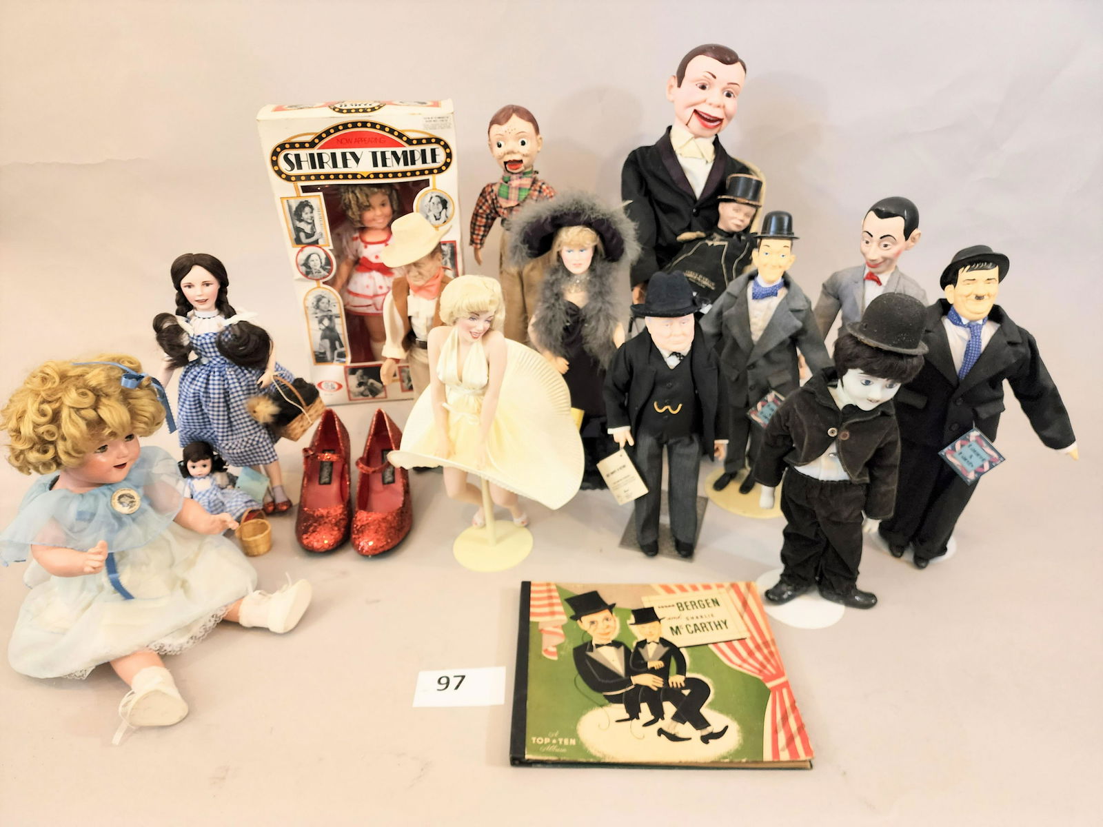 GROUP OF CELEBRITY DOLLS: Includes PeeWee Herman, two Shirley Temple dolls, one in box, Marilyn Monroe, Laurel and Hardy, Charlie McCarthy, Howdy Doody, John Wayne, Dorothy from The Wizard of Oz , Winston Churchill, and Mae We