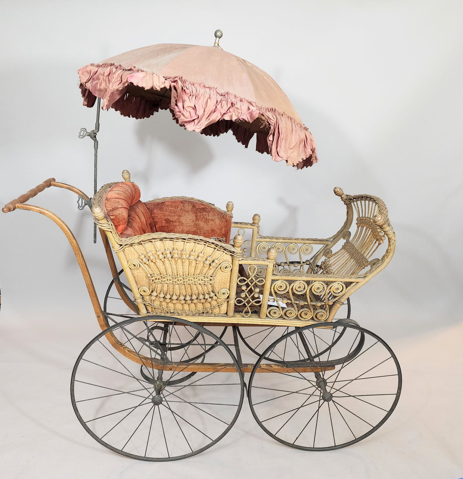 F.A. WHITNEY FANCY CARRIAGE: Elaborate curlicue and stick-and-ball design, and with original upholstery and original parasol. 46" long.