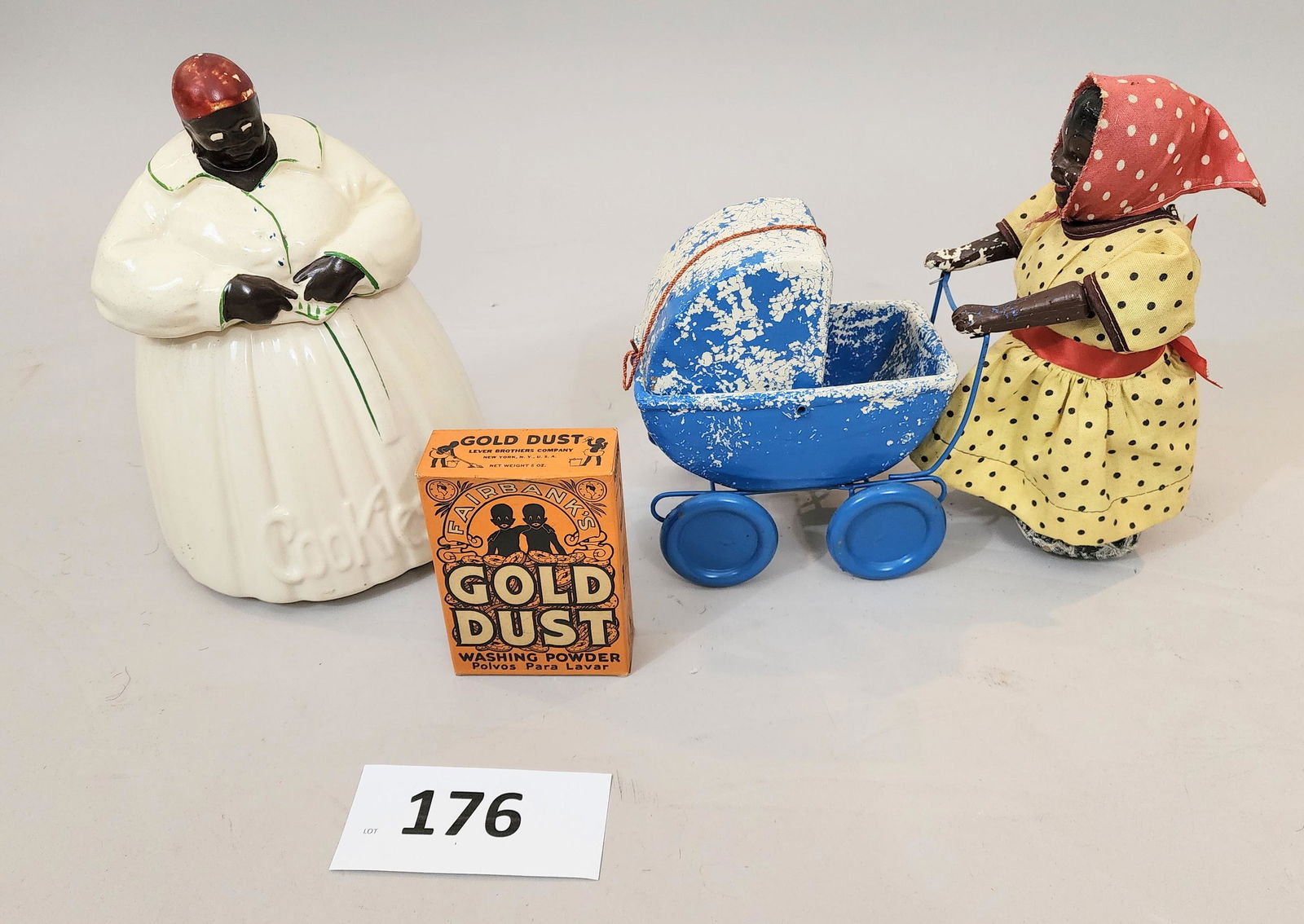 THREE AFRICAN AMERICANA ITEMS: Includes a "Mammy" pull toy, a McCoy "Mammy" cookie jar, and a box of Gold Dust powder with caricature depictions.