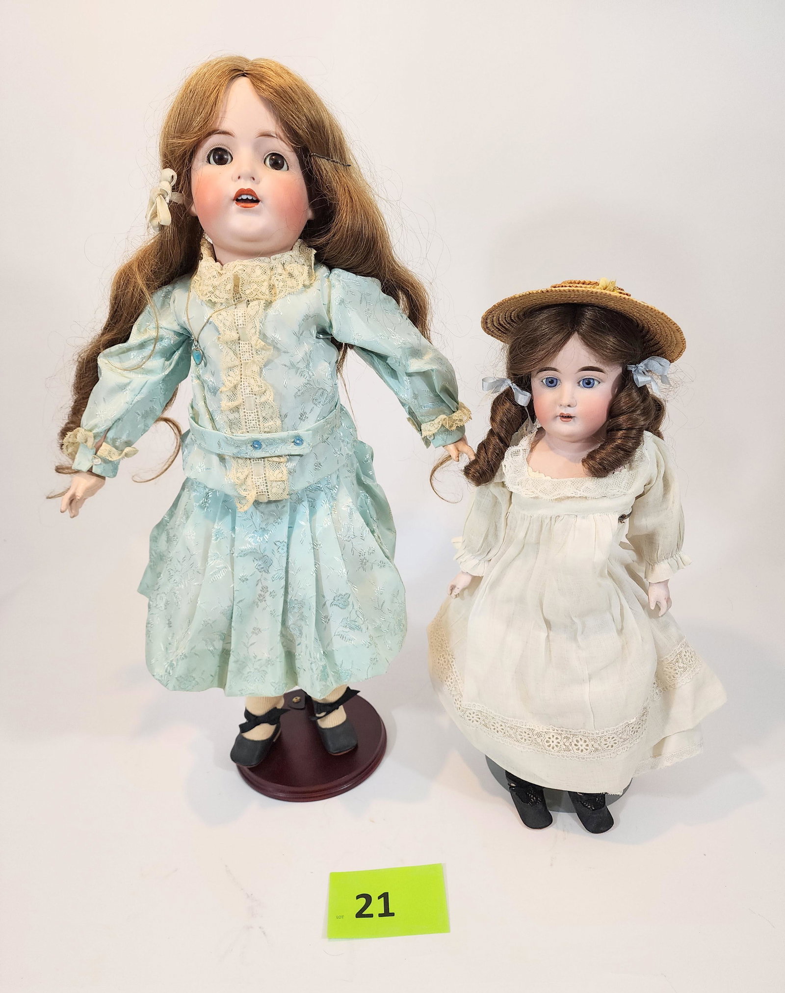 TWO BISQUE-HEAD DOLLS: Kestner J.D.K., sleepy eyes, open mouth with teeth, composition body, in vintage blue dress; with unmarked doll with stuffed leather body and later porcelain hands, open mouth with teeth, vintage whit