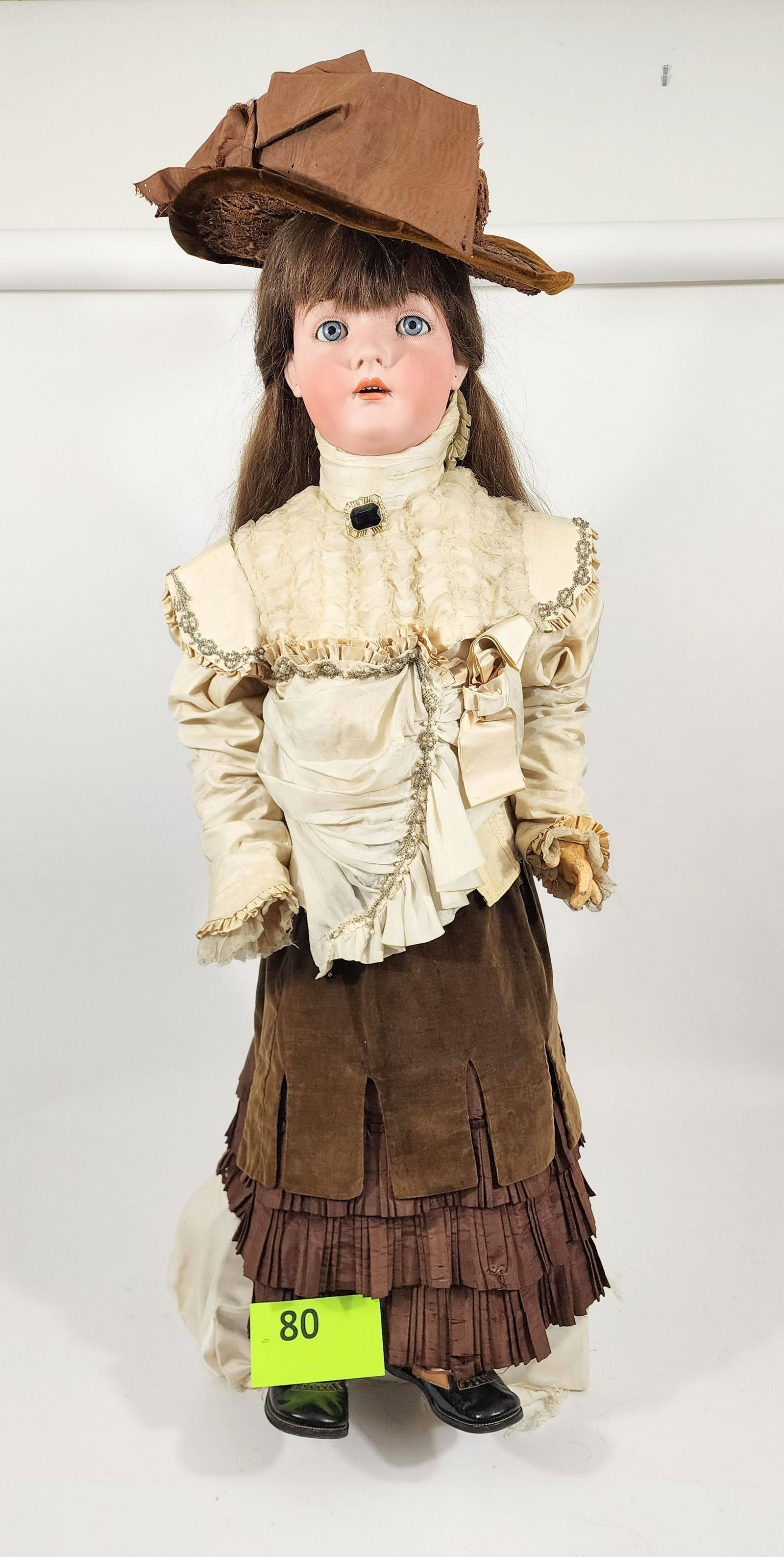 39" HALBIG DOLL: Large doll, bisque head and composition body, open mouth with teeth, pierced ears, straight chestnut hair and brown silk, lace, and velvet outfit with elaborate trim and pleating. 39" high.