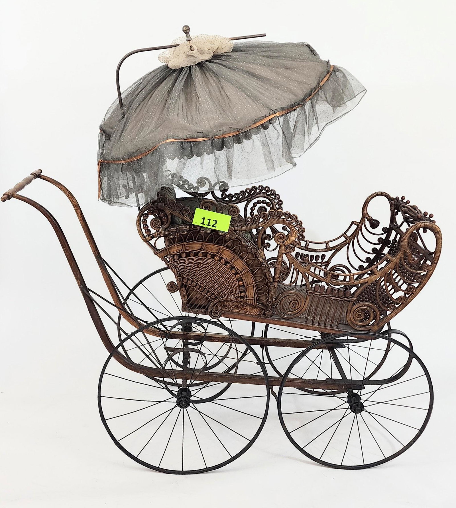 FANCY VICTORIAN BABY CARRIAGE WITH PARASOL: Stick-and-ball rattan work with curlicues and lyre-like design with elaborate work on dash. With original floral-on-blue-ground upholstery and original parasol mechanism. Includes cabinet card photogr