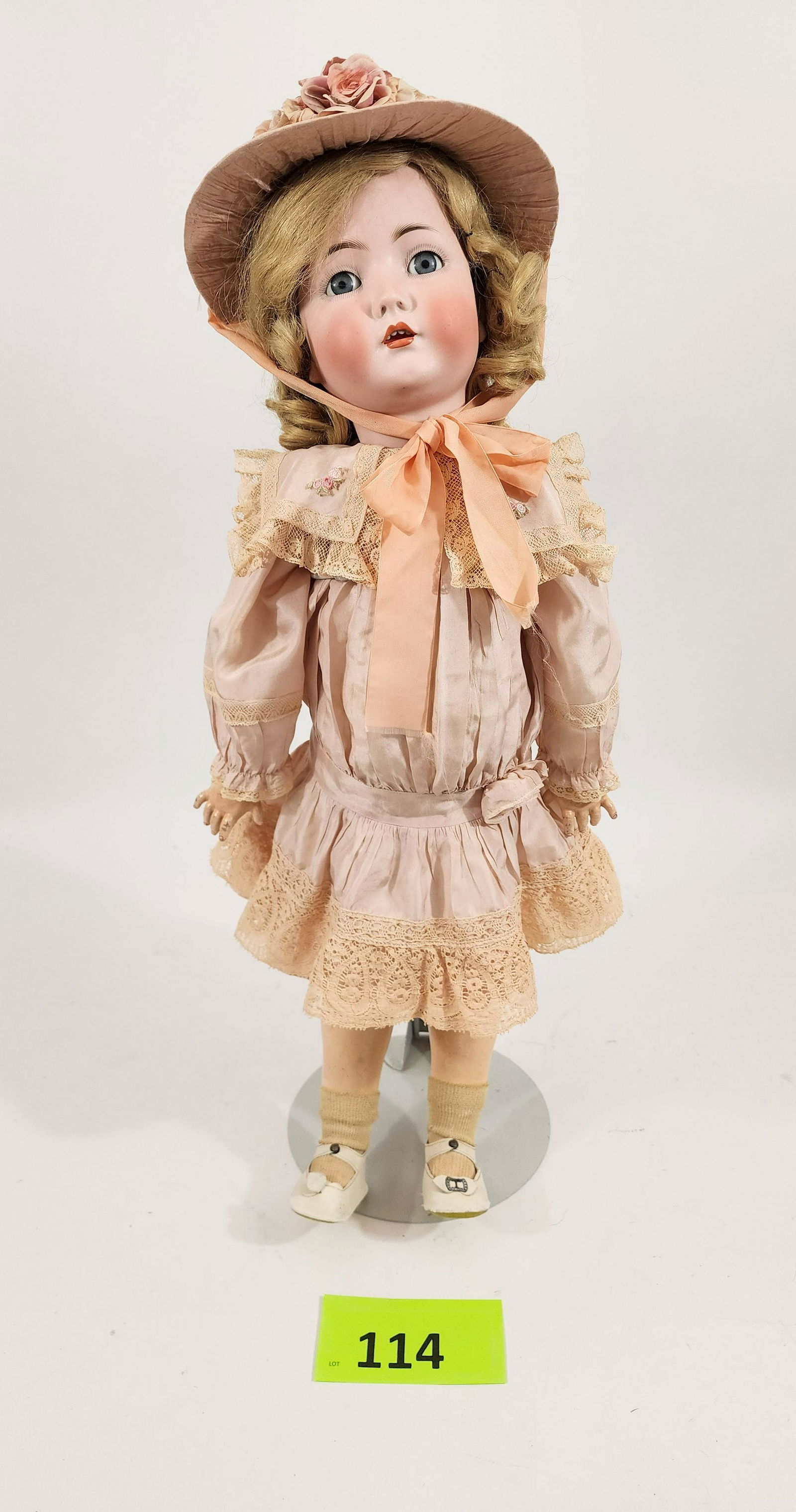 26" SIMON-HALBIG DOLL: Bisque head and composition body, sleep eyes, open mouth with teeth, blonde. Dressed in vintage pink silk dress with lace trim and matching bonnet. 26" high.