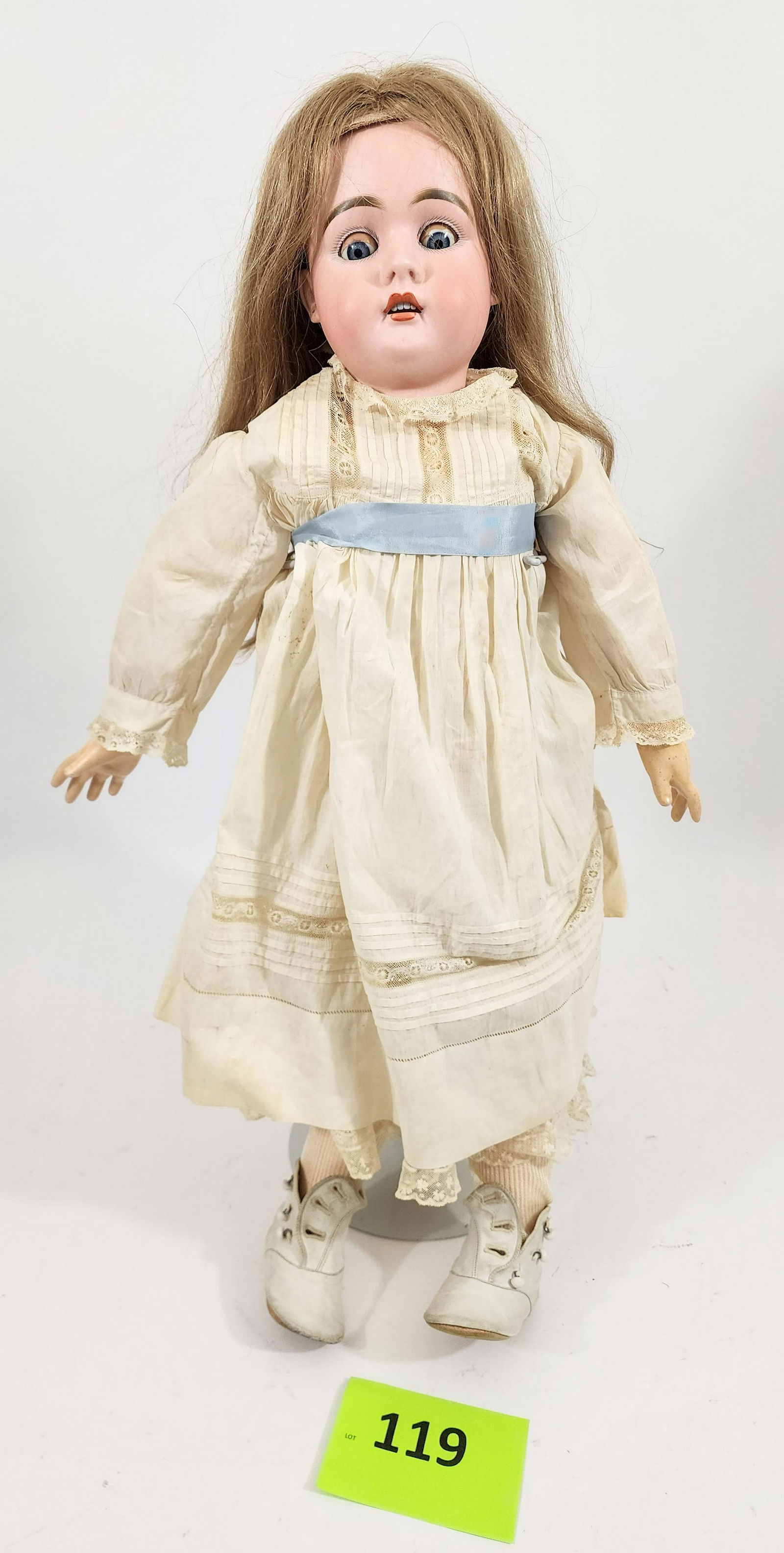 28" BAHR & PROSCHILD DOLL: Bisque head and composition body, sleepy eyes, open mouth with teeth, blonde hair, pierced ears, in white lace dress with blue sash. 28" high.