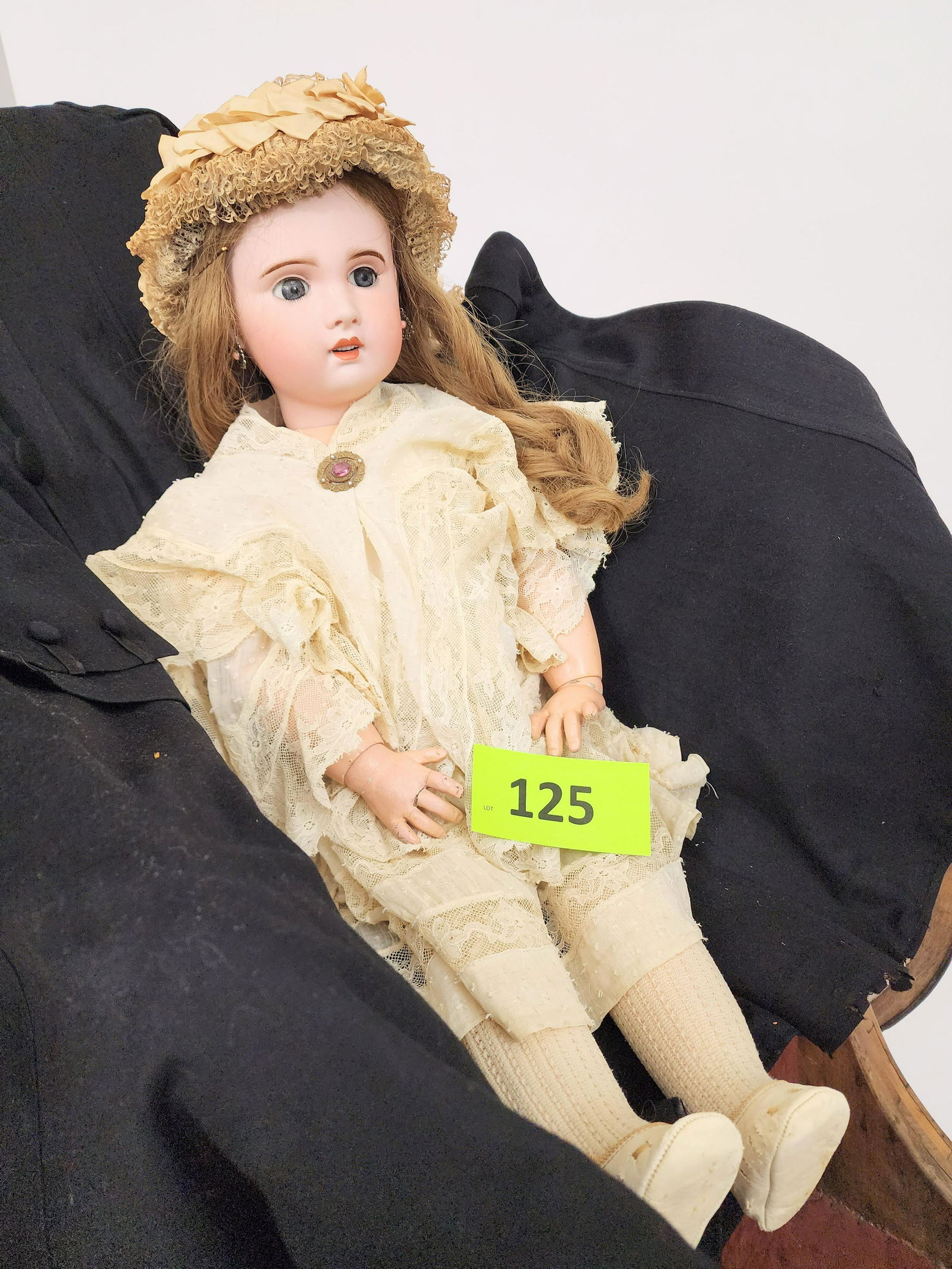 28" S.F.B.J. FRENCH SLEEPY-EYE DOLL: Bisque head and composition body, sleepy eyes, open mouth with teeth, pierced ears with drop earrings, vintage pin, chestnut curls, in lacy gown and frilly hat. 28" high.