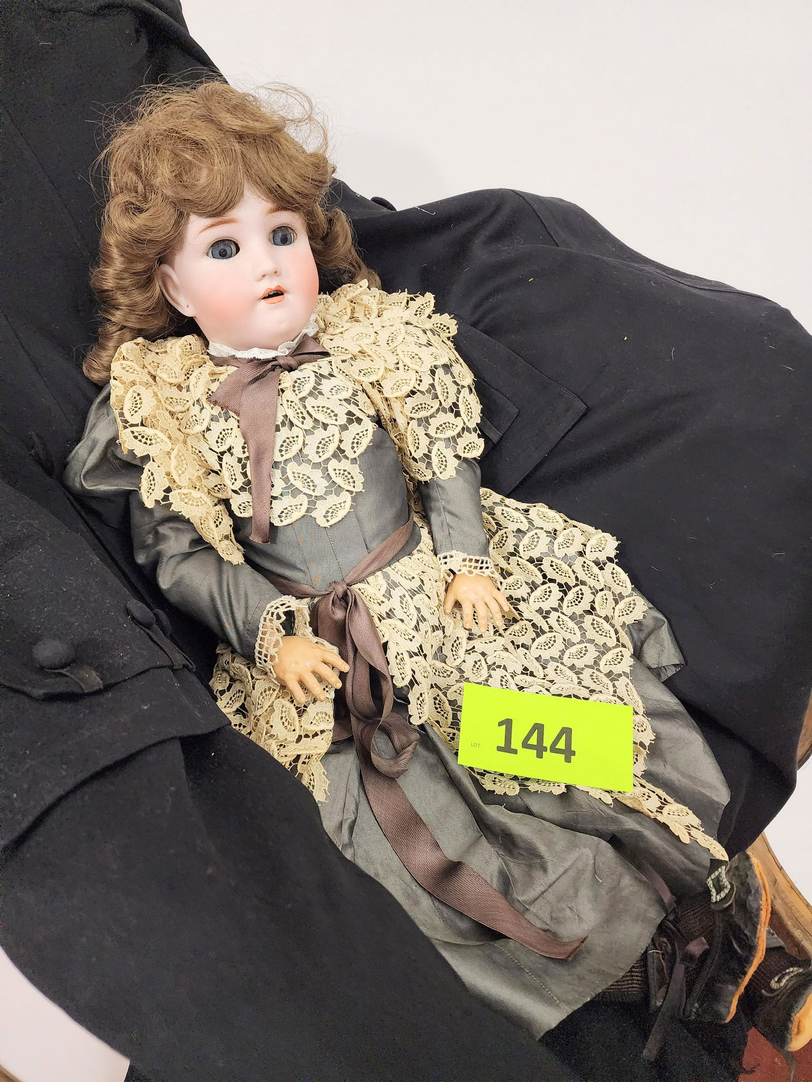 28" SIMON-HALBIG/HEINRICH HANDWERCK SLEEPY EYE DOLL: Bisque head and composition body, sleepy eyes, open mouth with teeth, pierced ears, brown curly hair, in gray polished cotton dress with two-piece lace overlay. 28" high.