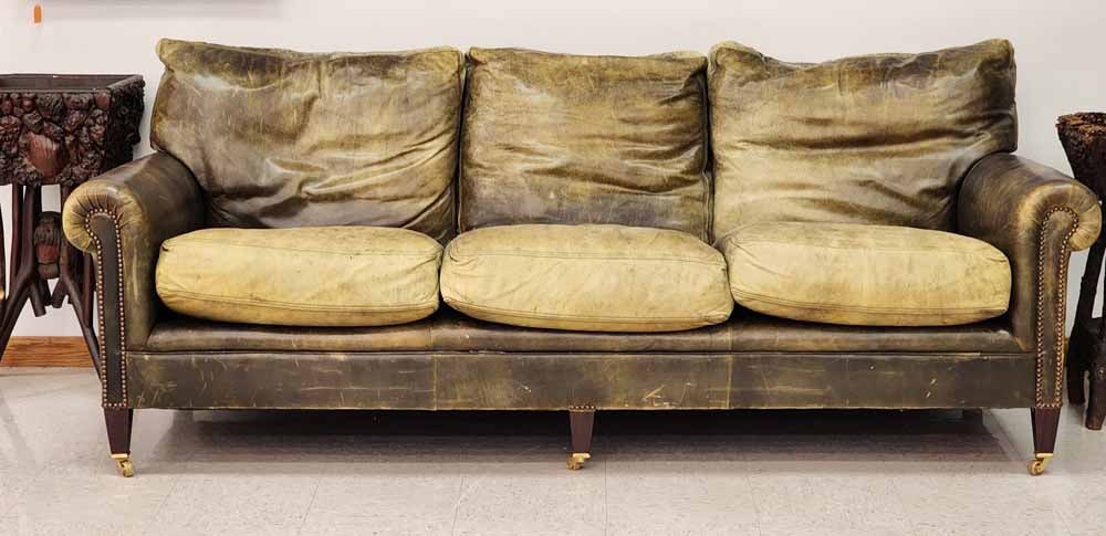 LEATHER SOFA: 20th century. Green leather on brass casters. 31" high, 84" long.