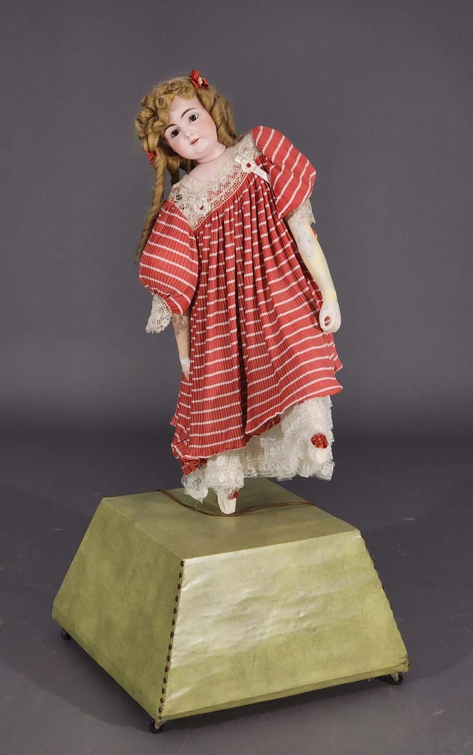 35" GERMAN DANCING DOLL: Bisque head with open mouth and teeth, composition arms and legs, mounted on an old mechanism that spins. 51" high overall.