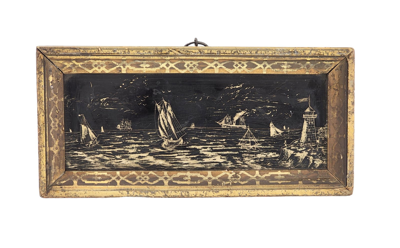 SCRIMSHAW SEASCAPE: Probably New England, mid-19th century. Panoramic coastal scene, with ten ships and a lighthouse, and with a figure on the cliff near the lighthouse. In its original frame, 4.25" high, 8.875" wide (ov