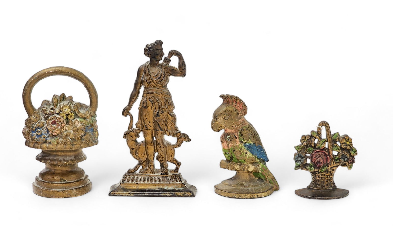 FOUR CAST IRON DOORSTOPS: American, early 20th century. Includes two flower baskets, a cockatiel, and Diana the Huntress (with either Syrius or Phocion). 5.5" to 12" high.