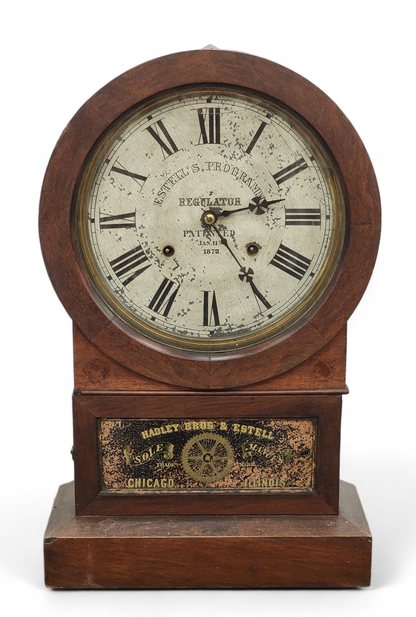 HADLEY BROS. ESTELL'S PROGRAMME CLOCK: Chicago, Illinois, 1871-1874, walnut. Reverse-painted tablet. 20.25" high.
