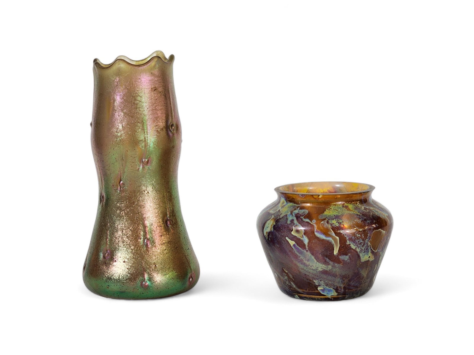 TWO PIECES OF IRIDESCENT ART GLASS: Early 20th century. Includes a scalloped-rim vase, possibly Loetz Astartig, 5" high; together with a small vase with a mottled iridescence, 2.25" high.
