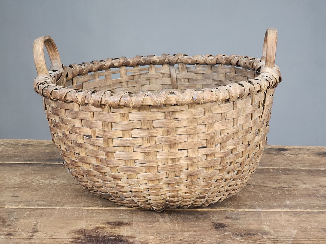 GATHERING BASKET: American, late 19th-early 20th century. Bushel-sized, round basket with loop handles. 21" diameter at the handles.