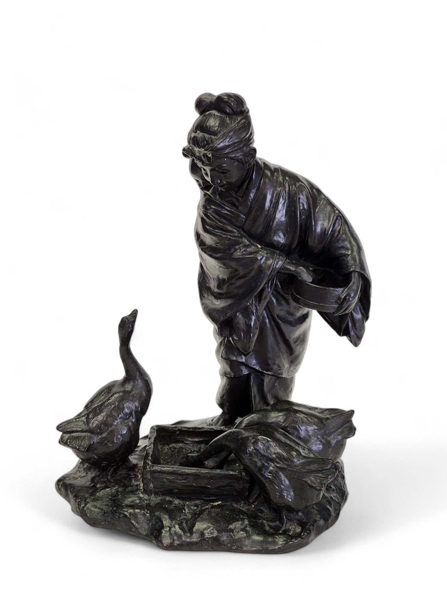 BRONZE MOTHER FEEDING THE GEESE: Unidentified signature, Asian, 20th century. Mother with a baby on her back and geese at her feet. 13" high.
