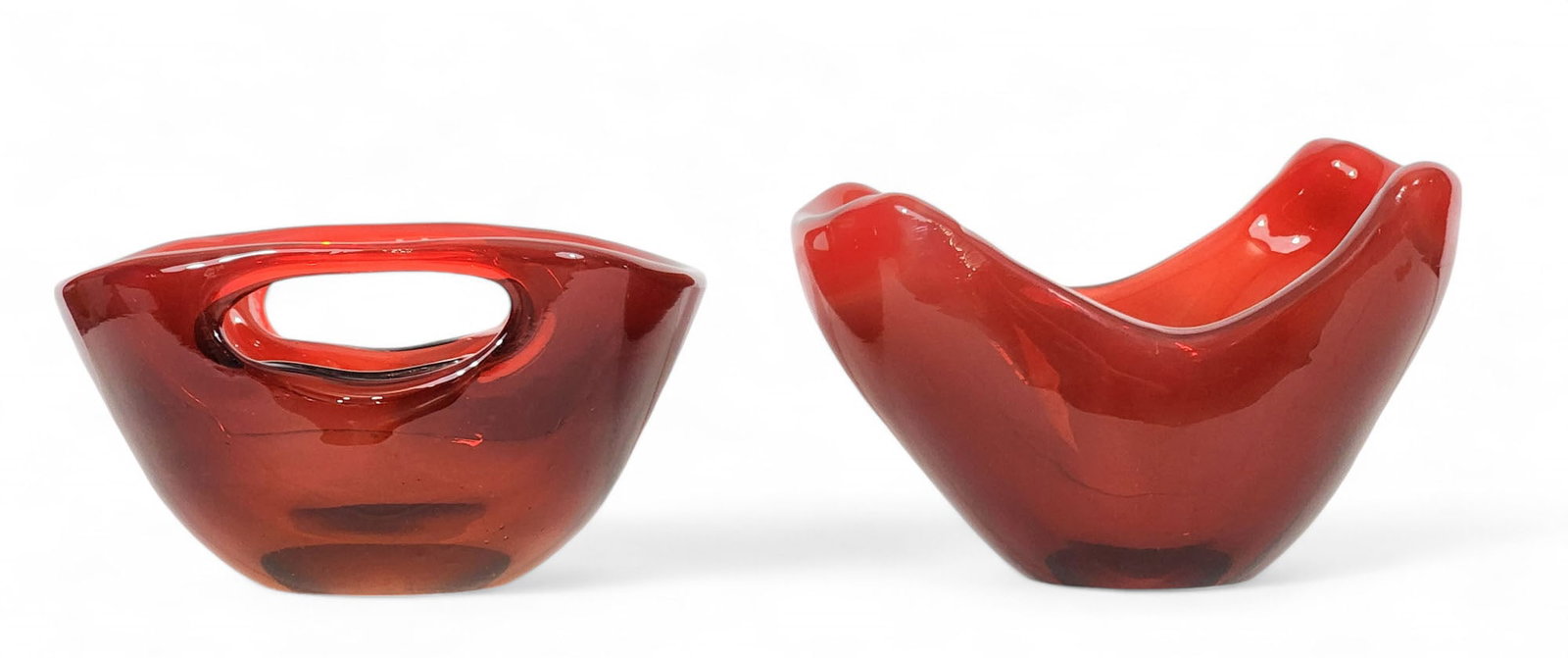 TWO BLENKO GLASS BOWLS: Milton, West Virginia, mid-20th century. In an unusual opaque and variegated red glass, and thickly made. Both are etched "Blenko." 4.5" high, 8.5" long and 4.75" high, 8.5" long.