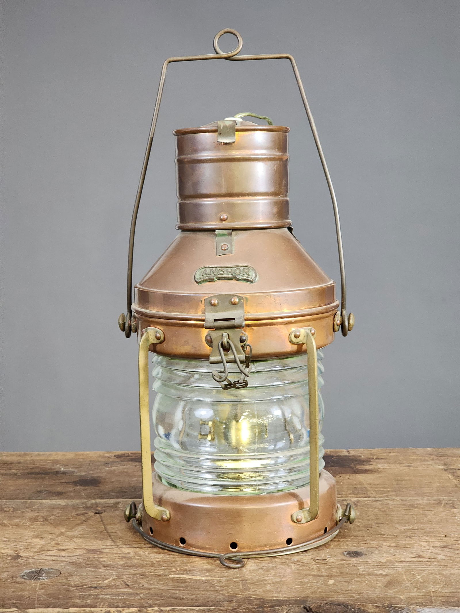 MARINE LANTERN: Anchor, 1st half-20th century, copper and brass. Round lantern with Fresnel lense and interior lamp. Sensitively electrified and now has a light mounted in the lid. 13.5" high (excluding handle).