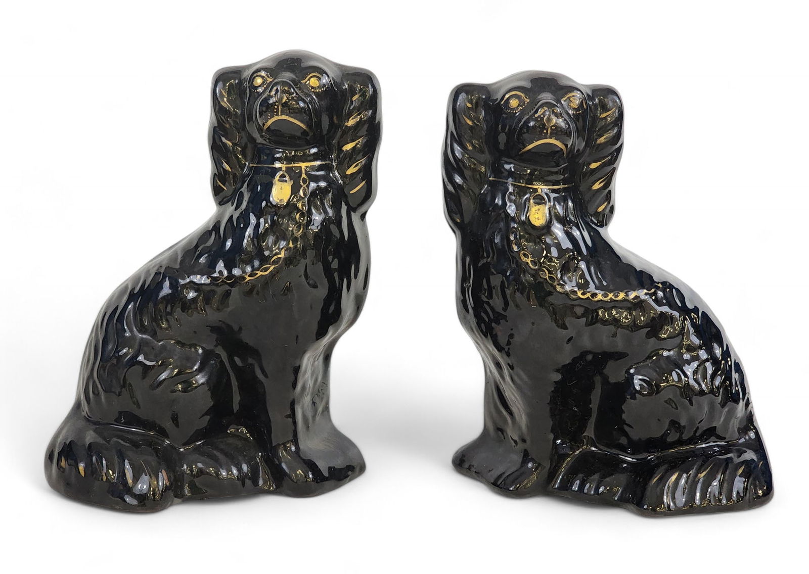 PAIR OF JACKFIELD SPANIEL CHIMNEY ORNAMENTS: English, late 19th century. Seated spaniels with black glaze on redware, with gilt accents. 9" high.