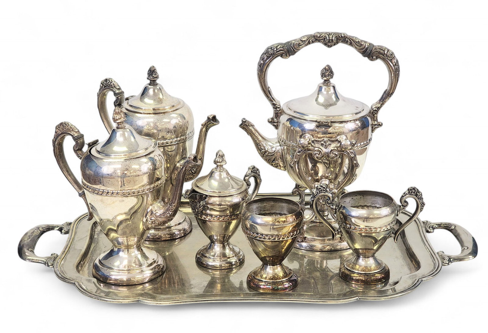 SILVER-PLATED TEA AND COFFEE SERVICE: 20th century. Includes teapot, coffee pot, hot water urn, covered creamer, open sugar, and waste bowl, and an associated tray. Urn is 12.5" high.